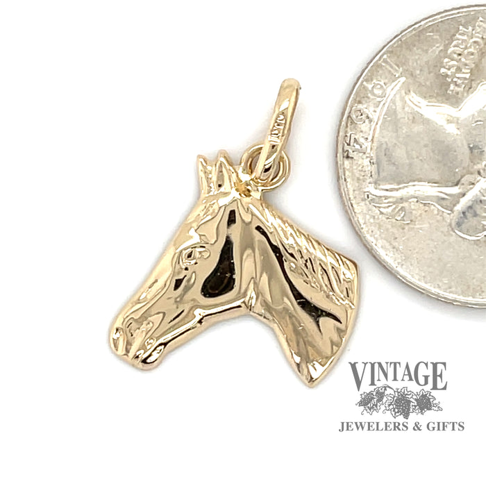 14k gold Horse head charm alongside a quarter for size reference