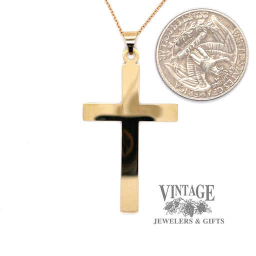 14 karat yellow gold flat solid cross, shown with quarter  for size reference