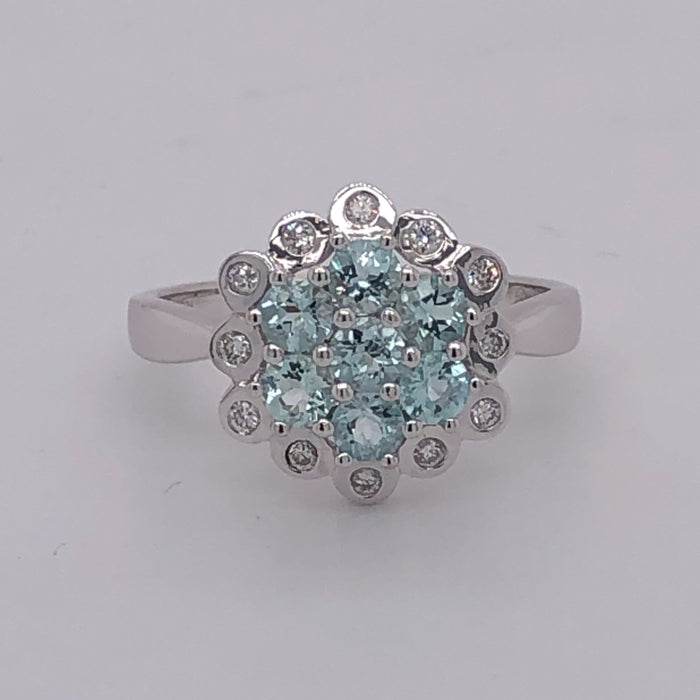18 karat white gold aquamarine cluster ring with diamond halo.