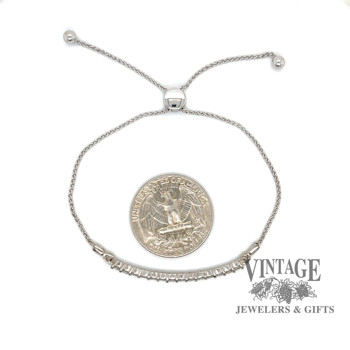 14 karat white gold diamond bar bolo bracelet with adjustable clasp, shown  with quarter for scale
