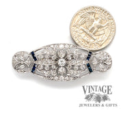 Edwardian platinum diamond and sapphire pin next to quarter for scale