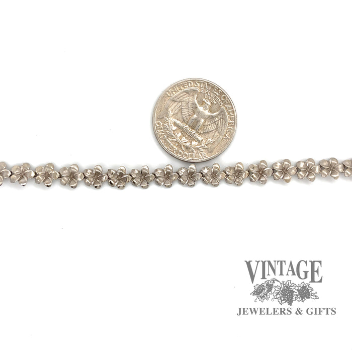 14 karat white gold 7.5" flower bracelet, shown with quarter for size reference