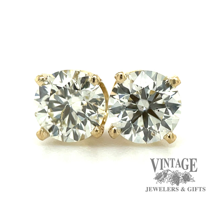 14 karat yellow gold .98 carat total weight natural round diamond stud earrings, close up