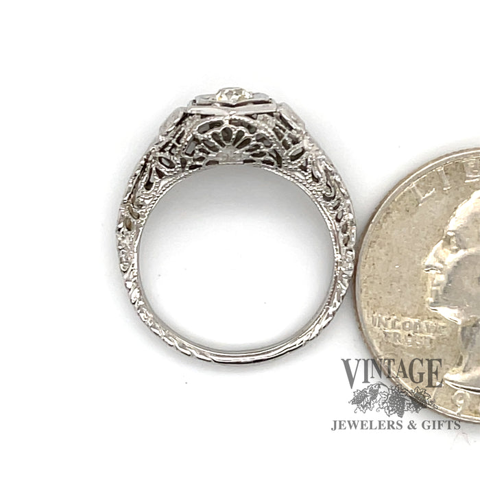18 karat white gold .25ct diamond filigree ring, side view through finger next to a quarter for size reference