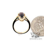 14 karat yellow gold 2.58 carat oval garnet and diamond ring, side through finger, shown with quarter for size reference