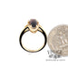 14 karat yellow gold 2.58 carat oval garnet and diamond ring, side through finger, shown with quarter for size reference
