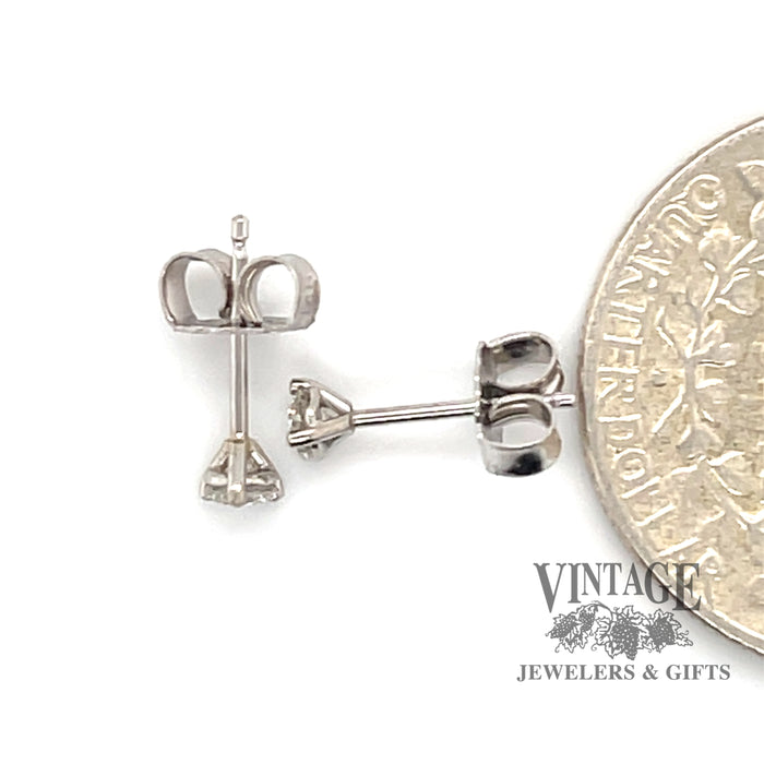 14 karat white gold .20 carat total weight diamond studs, martini style mounting, shown with quarter for size reference