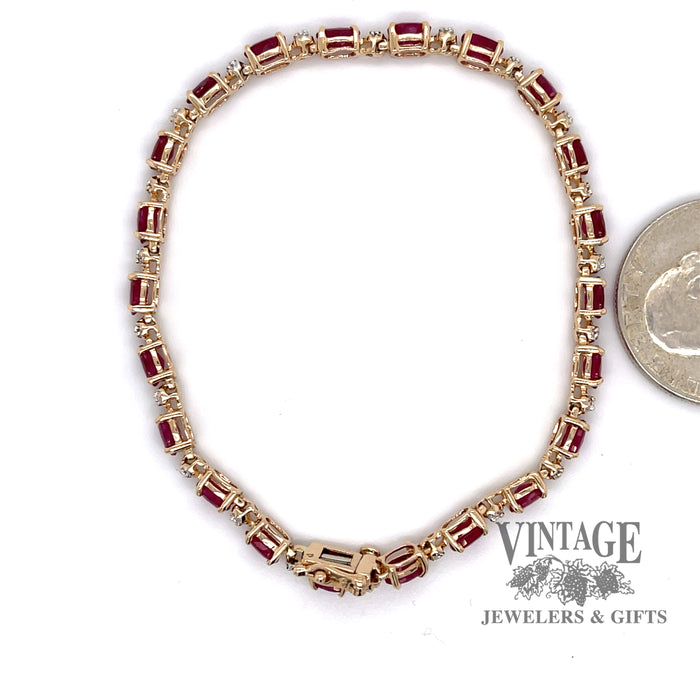 14 karat yellow gold ruby and diamond tennis bracelet, shown next to a quarter for size reference