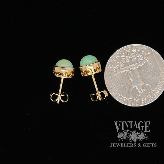 14 karat yellow gold 7mm round Ethiopian opal pierced stud earrings, side view showing gallery design and quarter for size reference