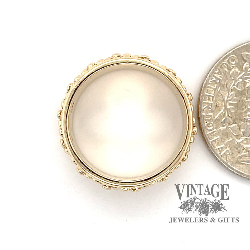 14 karat yellow gold wide estate beaded design band ring, side view through finger, shown with quarter for size reference