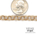 7.25" 14 karat yellow gold charm bracelet, shown with a quarter for size reference