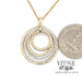 Multi circle 14k two tone gold and diamond pendant with quarter for scale