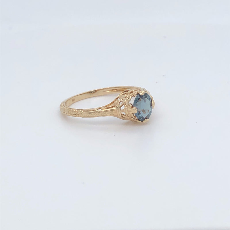 Picture of 14 karat yellow gold natural alexandrite ring from an angled view of front and side.