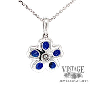 back view 18 karat white gold blue sapphire diamond flower pendant