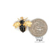 14 karat yellow gold blue sapphire bee pin shown with quarter for scale