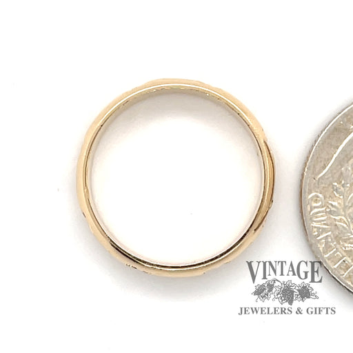 14 karat yellow gold four leaf clover pattern band ring, shown with quarter for size reference
