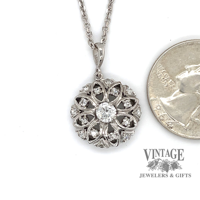 Estate 14 karat white gold round floral design diamond pendant, shown with quarter for size reference