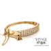 Bar set 14 karat yellow gold diamond bangle bracelet with heart and cross charm dangles, side view