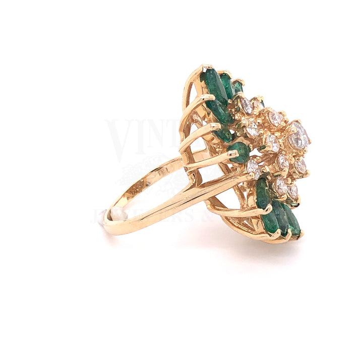 14 karat yellow gold marquise emerald cluster ring with round brilliant cut diamonds.