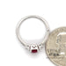 14 karat white gold 1.02ct Natural oval ruby and diamond ring, side view through finger next to quarter for size perspective
