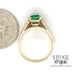 14 karat yellow gold .90ct Emerald and diamond ring, side view through finger with quarter for size reference